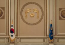 청와대 사랑채 재개관…주변 5가지 이색 여행 코스 선봬 a room with two flags and a coat of arms on the wall