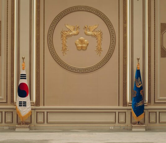 청와대 사랑채 재개관…주변 5가지 이색 여행 코스 선봬 a room with two flags and a coat of arms on the wall