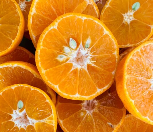 여름철 피부 톤 업 방법 a bunch of oranges that are cut in half