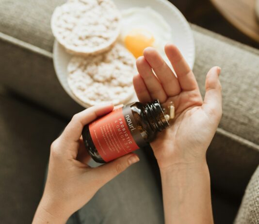 건강한 장을 위한 프로바이오틱스 person holding red bottle