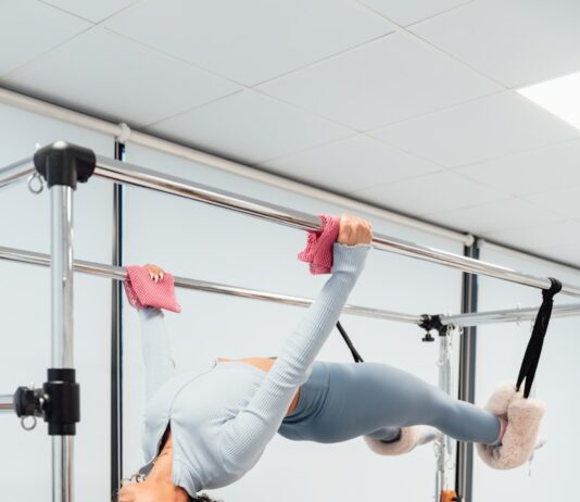 필라테스로 겨울철 굳어진 몸 풀기 a woman is doing a handstand on a parallel bar
