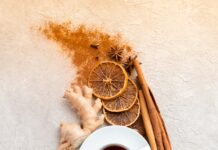 면역력을 높이는 겨울철 건강 음료 a cup of tea next to cinnamon, limes, limes and cinnamon sticks