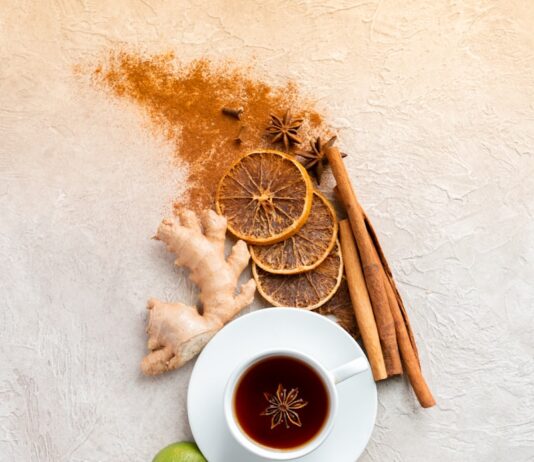 면역력을 높이는 겨울철 건강 음료 a cup of tea next to cinnamon, limes, limes and cinnamon sticks