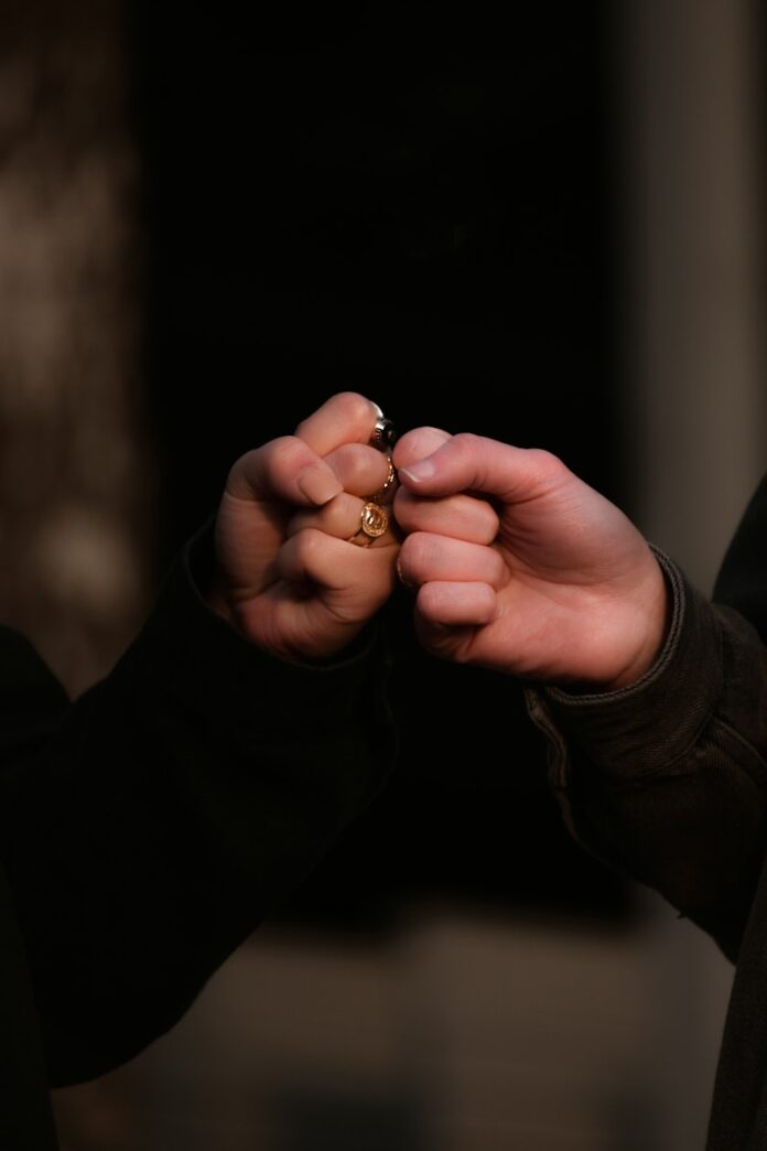Photo by Taylor Smith person holding gold ring in dark room