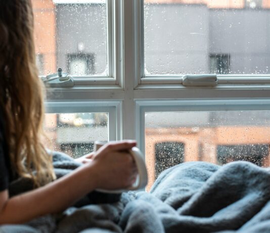 “비 오는 날이면 허리가 쑤셔요”…날씨와 관절통, 근거는 분명히 있다 woman in gray sweater sitting beside window