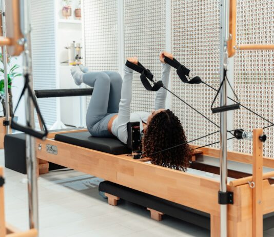 근력과 유연성을 향상시키는 필라테스 a woman is doing exercises on a rowing machine
