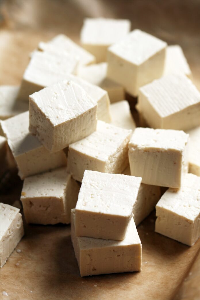 Photo by Kamala Bright A pile of tofu cubes sitting on top of a cutting board