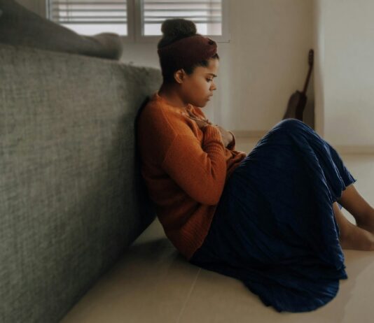 스트레스에 지친 현대인, 정신건강의 중요성 다시 생각해볼 때 man in orange long sleeve shirt sitting on gray couch