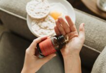 영양제, 어떻게 똑똑하게 챙길까? 한국인의 일상을 위한 실천 팁 person holding red bottle