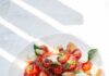 ‘마음 챙기는 식단’ 일상에 스며들다…건강도 맛도 챙기는 생활 속 실천법 sliced tomato and green leaf vegetable on white ceramic plate
